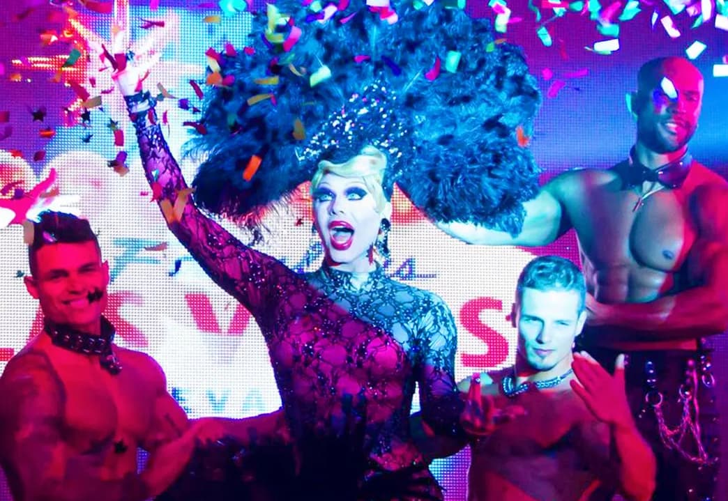 Drag Queen performing at a brunch event with handsome men in the background