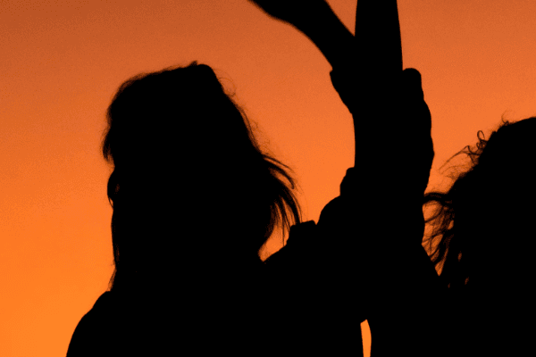 Silhouette of party goers celebrating while the sun sets